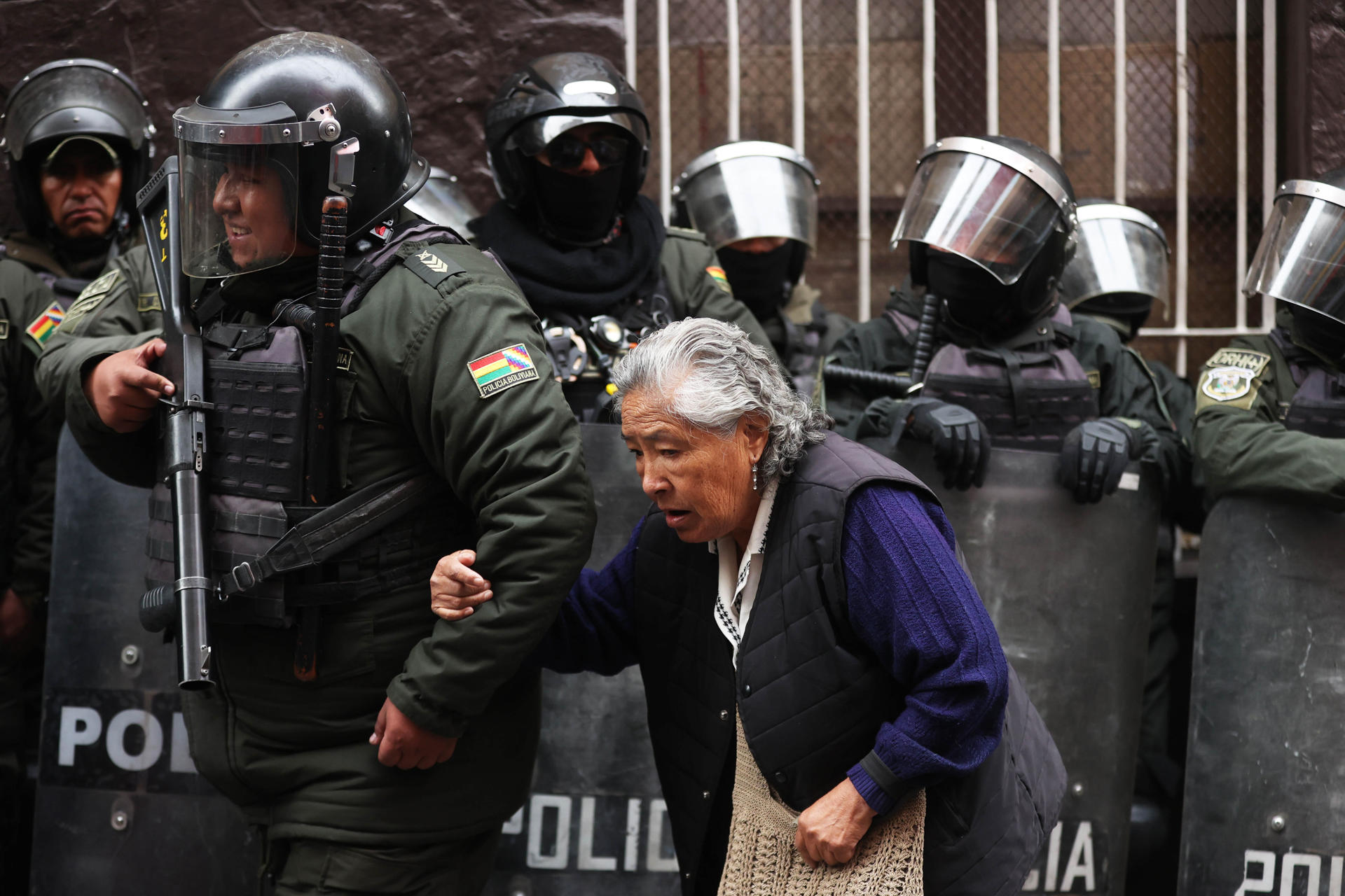 Un integrante de la Policía de Bolivia ayuda a una mujer durante una protesta este martes, en La Paz (Bolivia).EFE/ Luis Gandarillas
