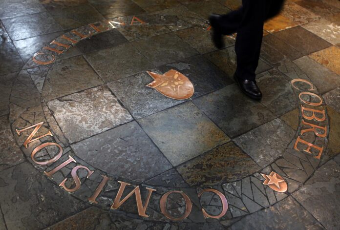Fotografía de archivo de los pies de un hombre al caminar sobre el logotipo de Cochilco (la Comisión Chilena del Cobre), en la sede del organismo, en Santiago de Chile. EFE/Felipe Trueba
