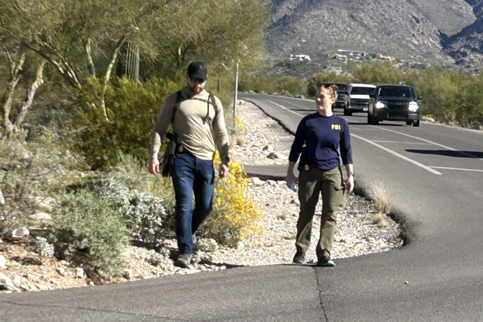 Dos agentes del FBI investigan en la zona que rodea la casa de Nancy Guthrie en Catalina Foothills, (Az, EE.UU.). Imagen de archivo. EFE/ María León
