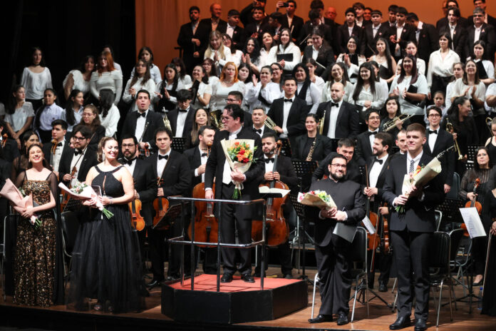 El maestro Diego Sánchez Hasse (c) y los músicos de la Orquesta Sinfónica del Congreso Nacional (OSIC) sostienen ramos de flores después de interpretar la Oda a la Alegría este 12 de mayo de 2026, en el Teatro Municipal en Asunción (Paraguay). EFE/ Juan Pablo Pino
