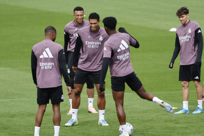 El centrocampista del Real Madrid, Aurélien Tchouaméni (2d), el centrocampista Jude Bellingham (3i) y el delantero Kylian Mbapeé (2i) durante el entrenamiento realizado este miércoles en la Ciudad Deportiva de Valdebebas en la víspera del encuentro liguero que el conjunto blanco disputa ante el Real Oviedo. EFE/Mariscal
