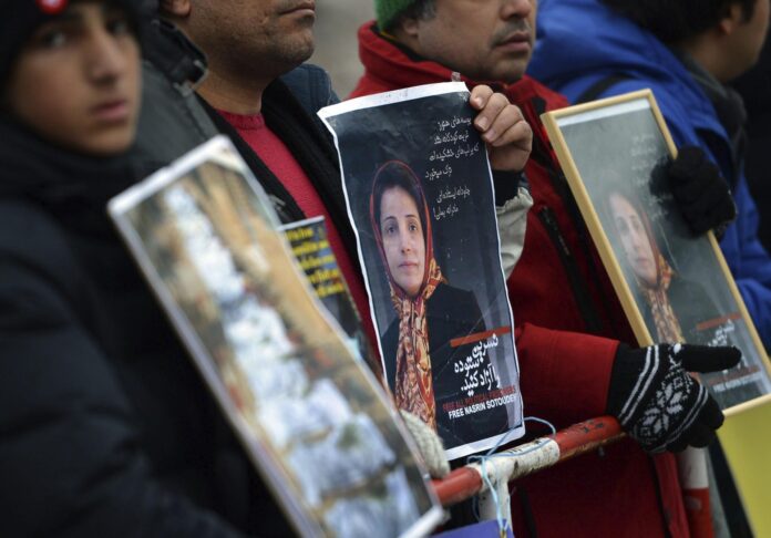 Unos manifestantes sujetan fotos de la abogada y defensora de los Derechos Humanos iraní Nasrin Sotudeh, encarcelada en la prisión de Evin de Teherán, en la embajada de Irán en Berlín, Alemania 10 de diciembre de 2012. EFE/Britta Pedersen
