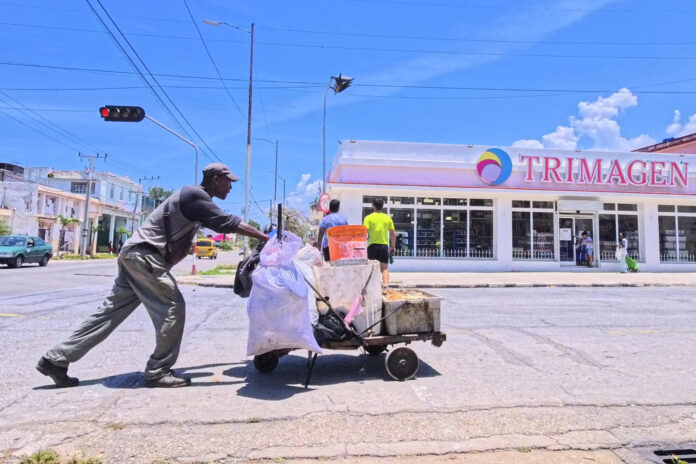 Un hombre fue captado este 13 de mayo al empujar una carretilla, frente a un tienda de gran superficie, en La Habana (Cuba). EFE/Ernesto Mastrascusa
