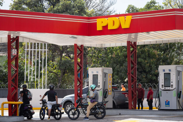 Fotografía de archivo de personas haciendo fila para abastecer sus vehículos de gasolina en una estación de servicio de la estatal petrolera Pdvsa en Caracas (Venezuela). EFE/ Ronald Peña R
