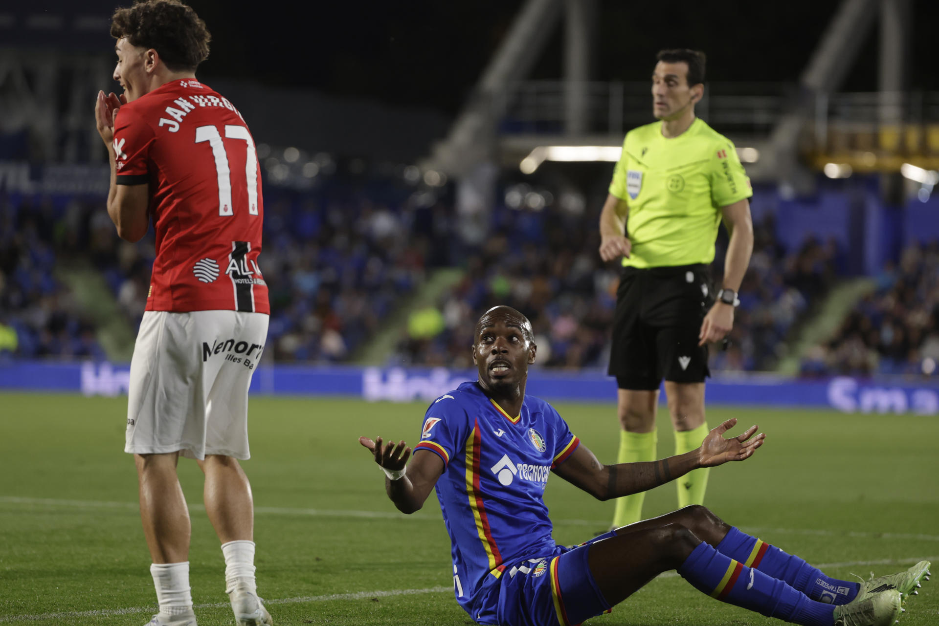El defensa camerunés del Getafe, Allan Nyom (d), se queja de una falta ante el delantero del Mallorca, Jan Virgili, durante el partido de la jornada 36 de LaLiga entre el Getafe y el Mallorca, este miércoles en el Coliseum de Getafe. EFE/ Juanjo Martín
