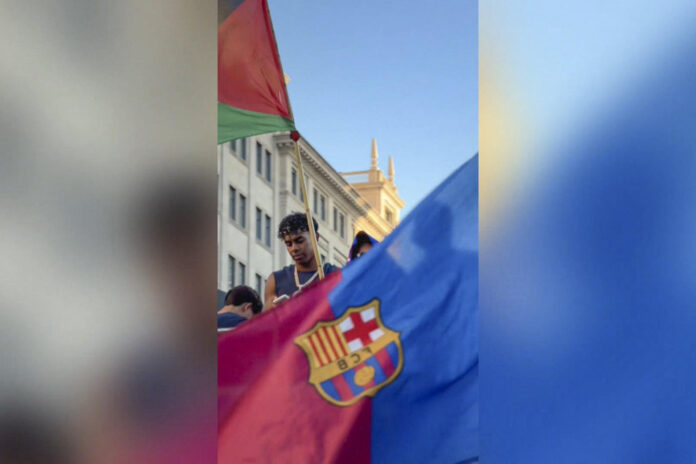 Imagen del delantero del Barcelona Lamine Yamal al ondear una bandera de Palestina durante la rúa de celebración del título de LaLiga. EFE/videoaficionada @Nuriacamera // SOLO USO EDITORIAL/SOLO DISPONIBLE PARA ILUSTRAR LA NOTICIA QUE ACOMPAÑA (CRÉDITO OBLIGATORIO)
