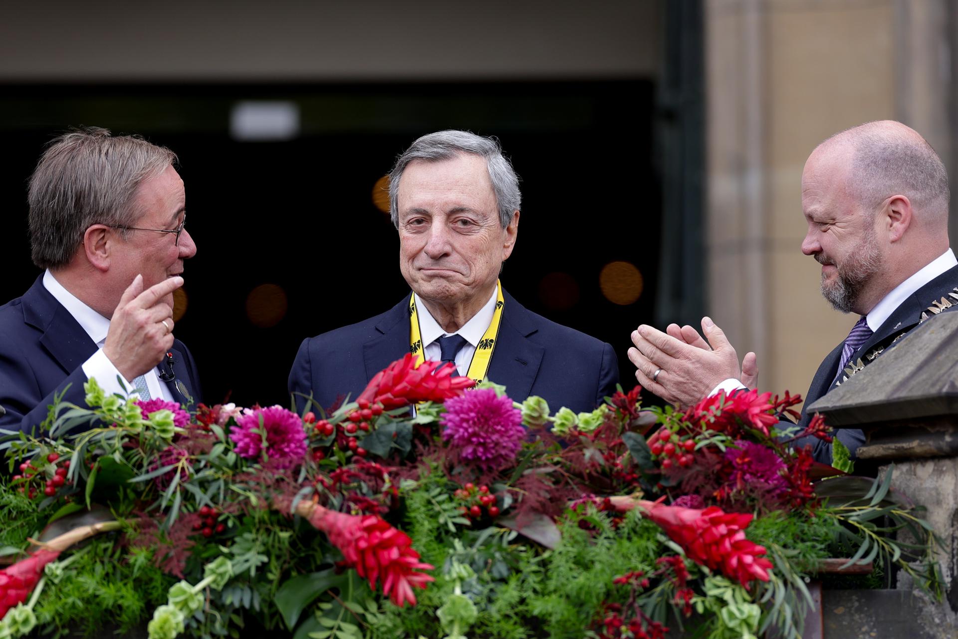 El expresidente del Banco Central Europeo Mario Draghi (C) posa en el balcón junto al presidente del Consejo de Administración del Premio Carlomagno, Armin Laschet (I), y el alcalde de Aquisgrán, Michael Ziemons (D), después de que Draghi recibiera el Premio Carlomagno (Karlspreis) durante la ceremonia de entrega de premios en el ayuntamiento de Aquisgrán, Alemania, el 14 de mayo de 2026. Según el Consejo del Premio Carlomagno, el profesor Mario Draghi es homenajeado por sus destacadas contribuciones a la integración europea y por su papel decisivo en la estabilización y el desarrollo posterior de la Unión Económica y Monetaria Europea. (Alemania) EFE/EPA/CHRISTOPHER NEUNDORF
