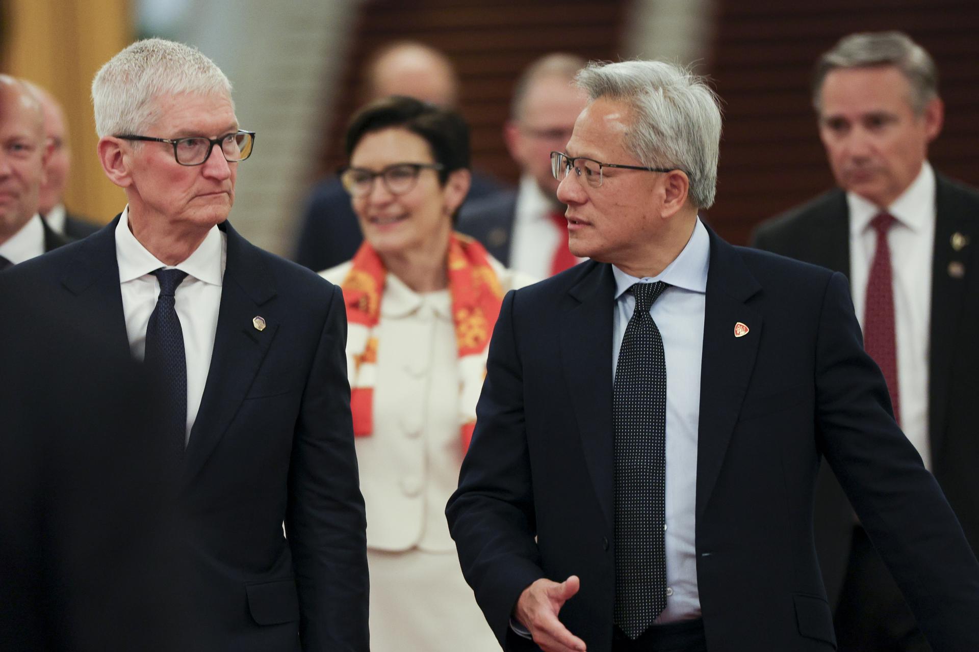 El presidente y director ejecutivo de Nvidia, Jensen Huang (2-D), y el presidente de Apple, Tim Cook (I), llegan este jueves a la reunión entre el primer ministro chino, Li Qiang, y representantes de negocios de EE.UU., en el Gran Salón del Pueblo en Pekín. EFE/EPA/GO NAKAMURA / POOL
