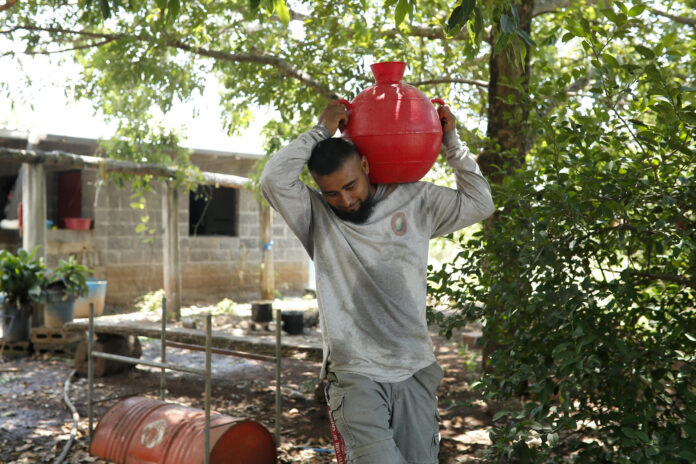 Un hombre utiliza un cántaro para almacenar agua este martes, en Nueva Concepción (El Salvador). EFE/Rodrigo Sura
