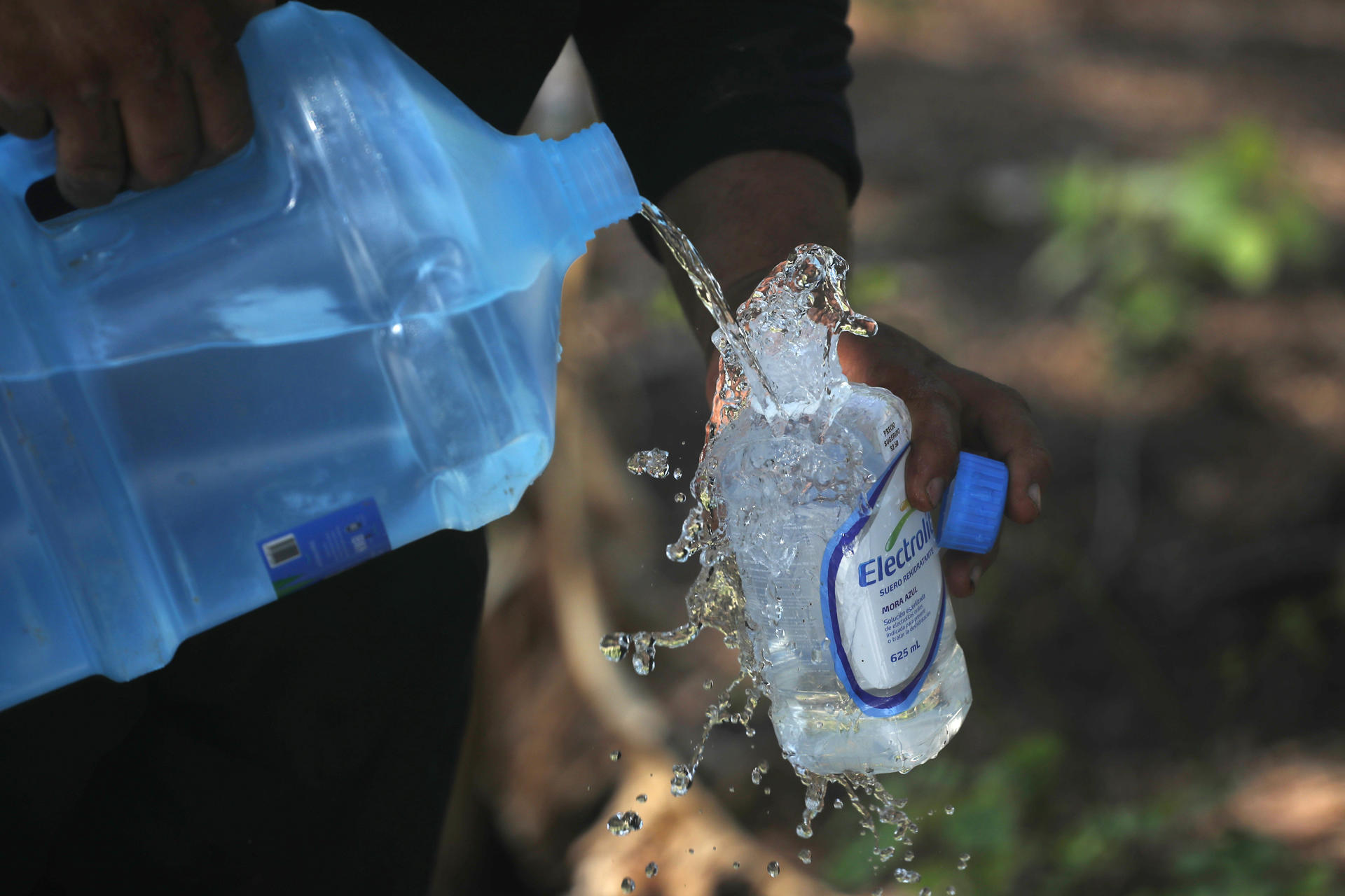 Un trabajador se sirve agua en la zona donde se habilitará un pozo como parte del proyecto Agua Segura este martes, en Nueva Concepción (El Salvador). EFE/Rodrigo Sura
