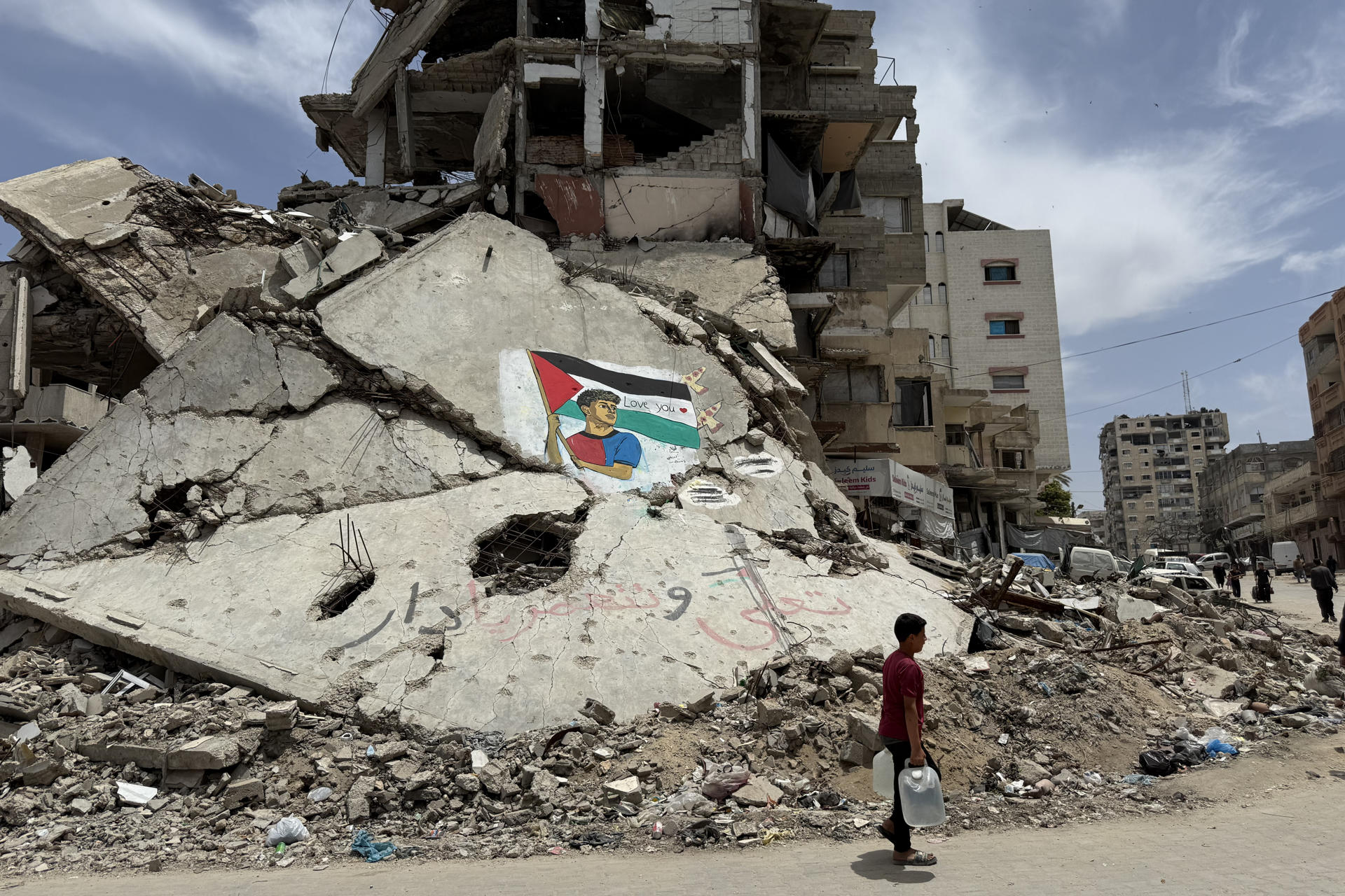 - Dos artistas palestinos pintaron un mural del futbolista Lamine Yamal sujetando una bandera palestina sobre las ruinas de una casa destruida por ataques israelíes en el campamento de refugiados de Al Shati, al oeste de la ciudad de Gaza. "Derrotaron a Israel y también al Real Madrid. Y para nosotros, es un orgullo ser seguidores del Barcelona", dice a EFE el gazatí Amir Badah, de 18 años, frente a este mural. En el dibujo se ve al culé, alzando la bandera como hizo el lunes durante la rúa de los jugadores del Barça tras ganar la Liga, y en sobre la franja blanca de la enseña palestina hay escrito un "Love you" ('te queremos'), con un corazón rojo. EFE/Ahmad Awad

