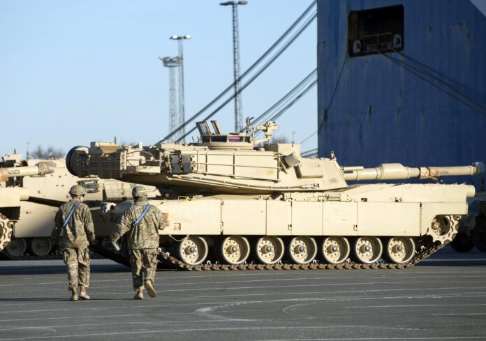 Fotografía de archivo de un par de soldados al caminar frente a uno de los tanques del Ejército de EE.UU. en el puerto de Bremerhaven (norte de Alemania). EFE/David Hecker
