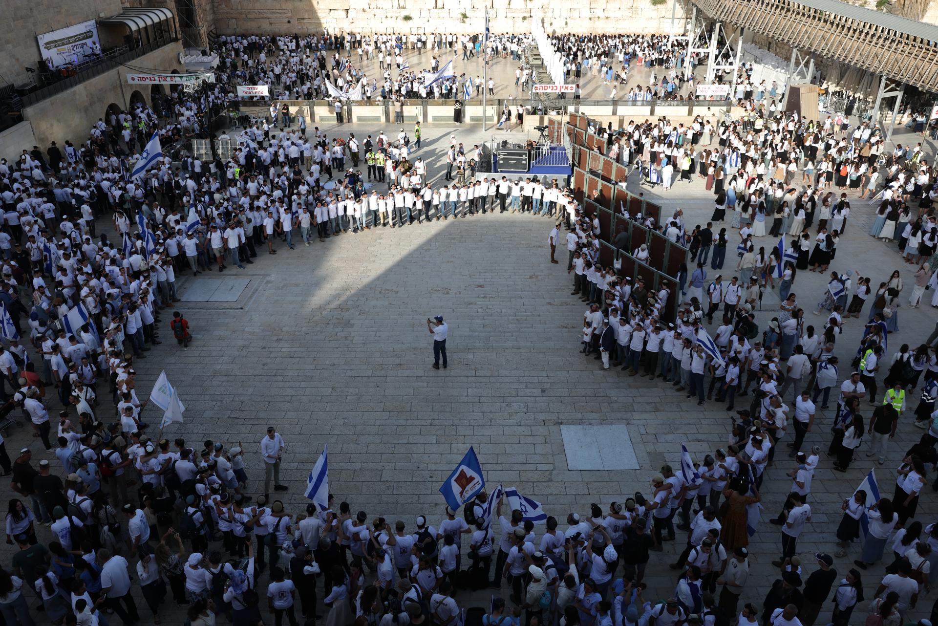Jóvenes israelíes rezan en la Explanada de los Muros y bailan con banderas durante las celebraciones del 59º Día de Jerusalén y la 'Marcha de las Banderas' en la Ciudad Vieja de Jerusalén, 14 de mayo de 2026. La marcha anual conmemora el establecimiento del control israelí sobre la Ciudad Vieja y sus lugares sagrados tras la Guerra de los Seis Días de 1967. (Jerusalén) EFE/EPA/ABIR SULTAN
