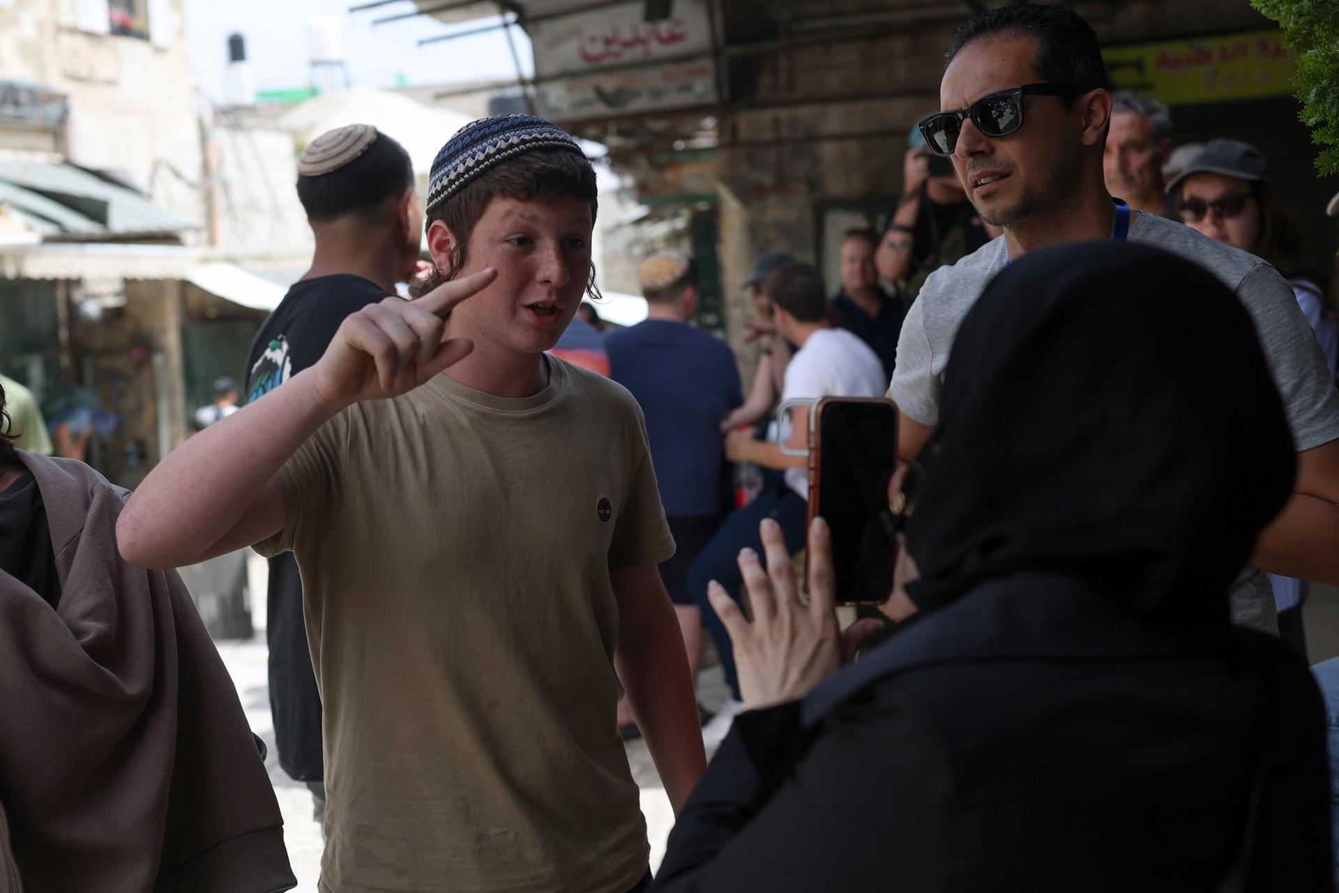 Un joven de derechas israelí discute con una mujer palestina durante la anual 'Marcha de las Banderas' en la Ciudad Vieja de Jerusalén, el 14 de mayo de 2026. La marcha conmemoró el establecimiento del control israelí sobre la zona tras la Guerra de los Seis Días de 1967. (Jerusalén) EFE/EPA/ATEF SAFADI
