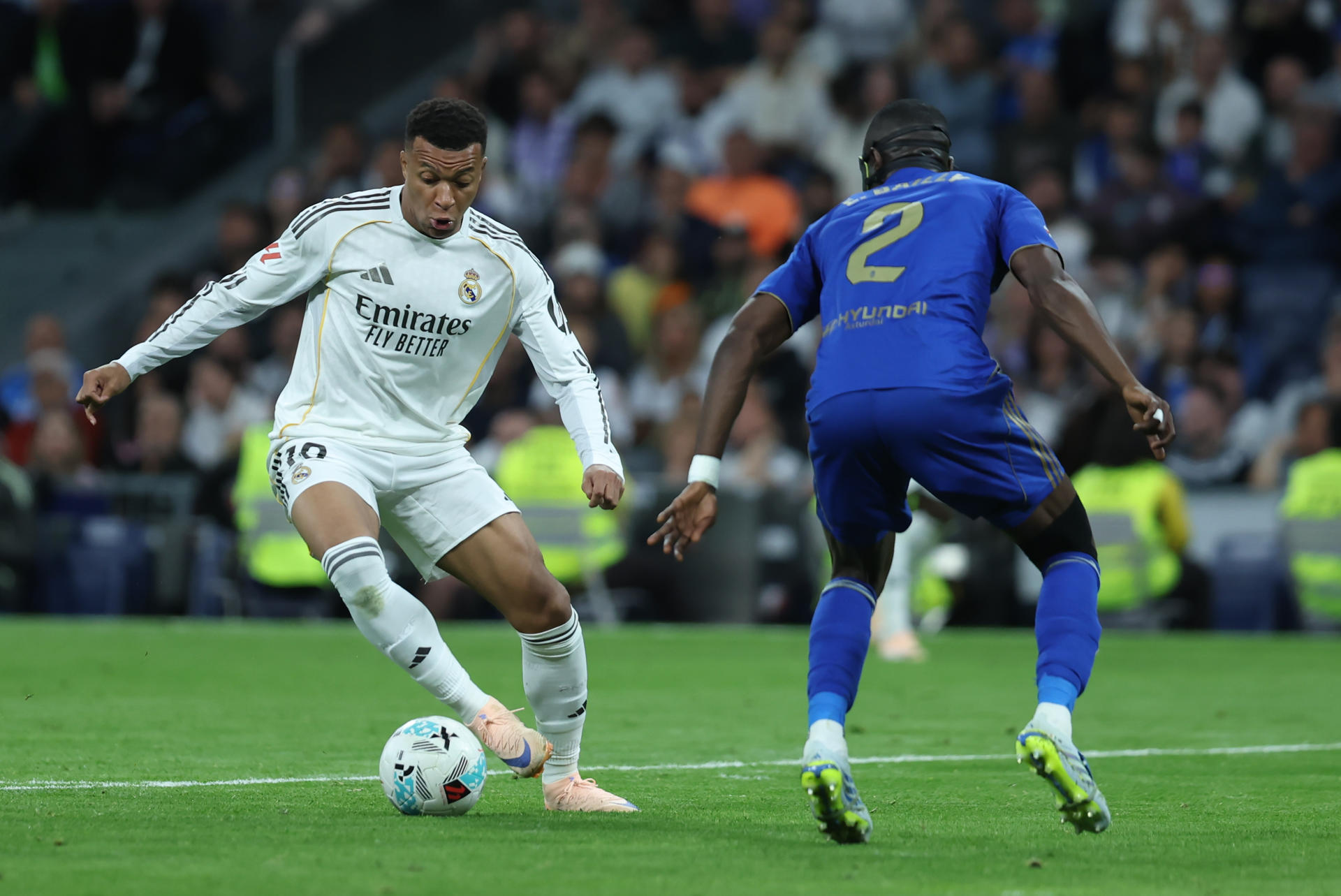 El delantero del Real Madrid Kylian Mbappé (i) se escapa de Eric Bailly, del Oviedo, durante el partido de la jornada 36 de LaLiga que Real Madrid y Real Oviedo disputan este jueves en el estadio Santiago Bernabéu. EFE/Kiko Huesca
