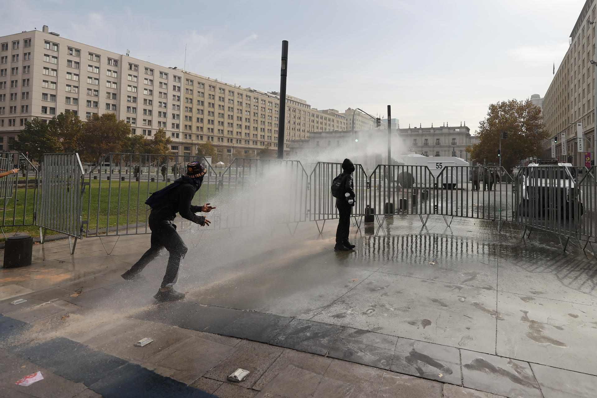 Un par de encapuchados fue captado este 14 de mayo al enfrentarse a miembros de los Carabineros, durante una protestas estudiantil en contra de los recortes económicos ejecutados por el Gobierno de José António Kast, en Santiago de Chile. EFE/Elvis González
