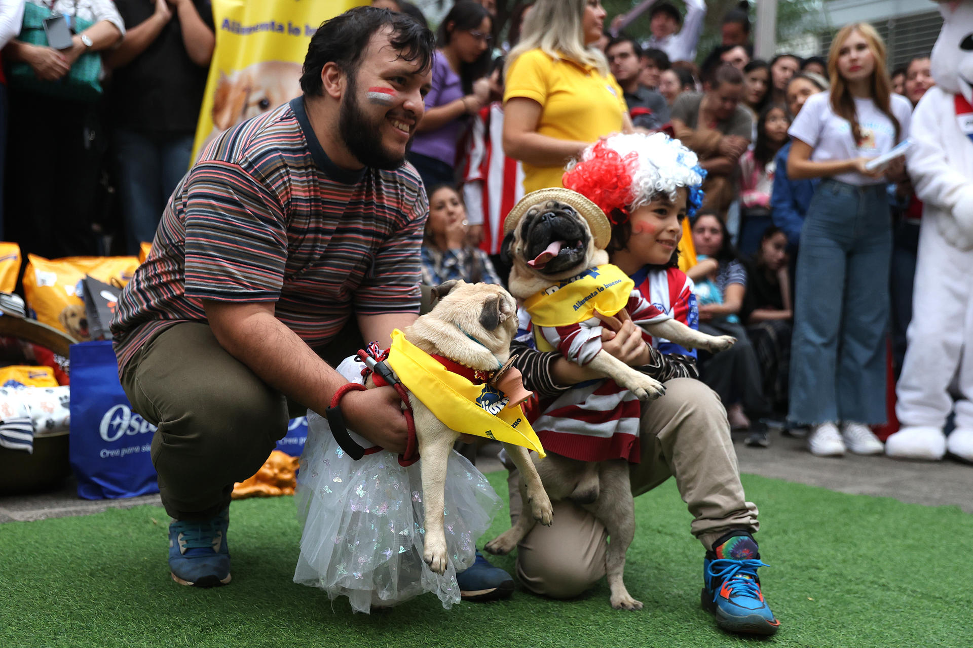 Personas posan con sus mascotas en el desfile de la celebración del ‘Jagua Patriota’ (Jagua es perro en guaraní) este jueves, en Asunción (Paraguay). EFE/ Juan Pablo Pino
