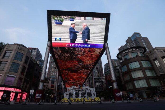 El presidente chino, Xi Jinping, y el presidente estadounidense, Donald Trump, se saludan en una pantalla gigante en Pekín. EFE/EPA/WU HAO
