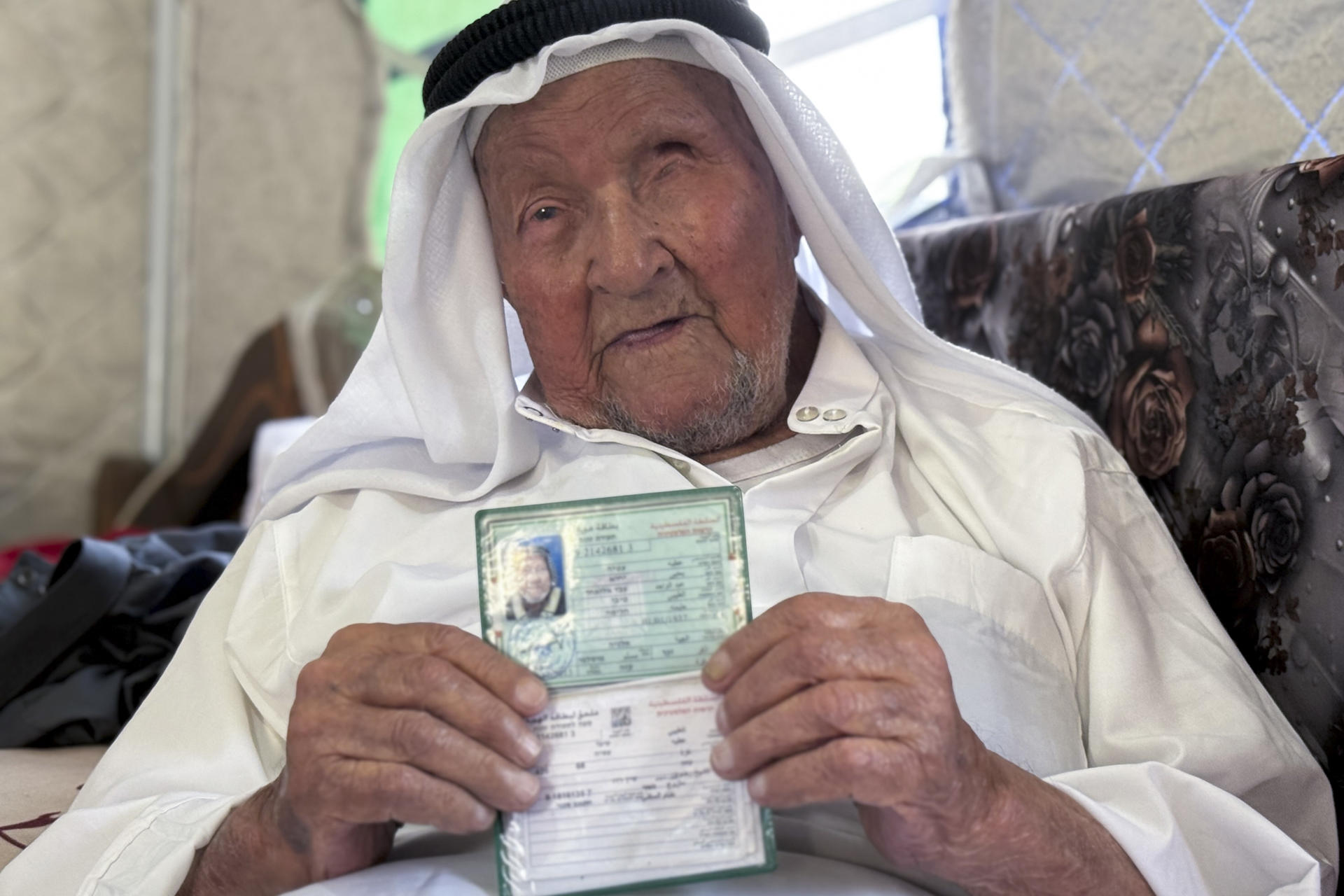 Yahya Abdelwahid Al Taybi, de 90 años, posa en la tienda de campaña en la que se encuentra refugiado junto a su familia en el barrio de Sheij Radwan de la ciudad de Gaza.. EFE/ Ahmad Awad
