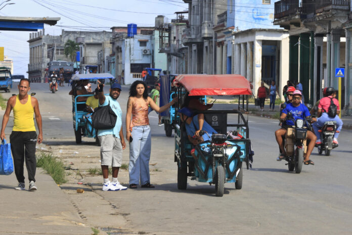 Un grupo de personas fue captado este 14 de mayo al transitar por una calle de La Habana (Cuba), durante un apagón eléctrico generalizado que afectó al 70 %  de la isla. EFE/Ernesto Mastrascusa
