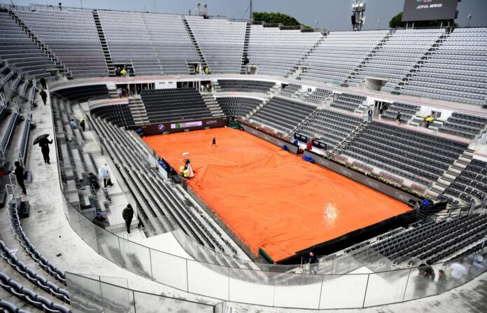 Un miembro del personal despliega las lonas impermeables durante el partido entre el italiano Luciano Darderi y el noruego Casper Ruud en el torneo de tenis Open de Italia, celebrado en Roma. EFE/EPA/ETTORE FERRARI
