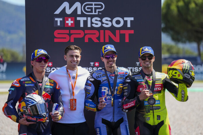 El piloto español Álex Márquez (2d) (Ducati Desmosedici GP26) , ganador de la 'sprint' del Gran Premio de Cataluña, posa junto a Pedro Acosta (i) (KTM RC 16), segunda posición, y Fabio di Giannantonio (d), (Ducati Desmosedici GP26), tercero, este sábado en el circuito de Barcelona. Junto a ellos, el futbolista del FC Barcelona Fermín López (2i). EFE/Alejandro García
