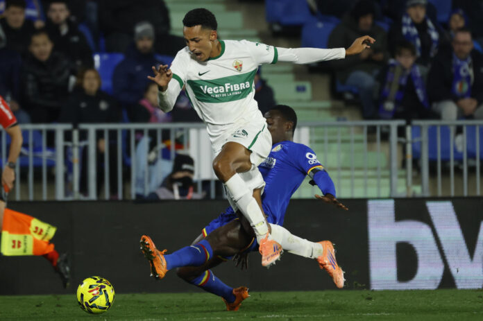 El delantero uruguayo del Elche, Álvaro Rodríguez, cae ante la entrada de Djené, del defensor del Getafe durante el partido de LaLiga entre Getafe CF y Elche CF de la primera vuelta en el Coliseum en foto de archivo de Juanjo Martín . EFE
