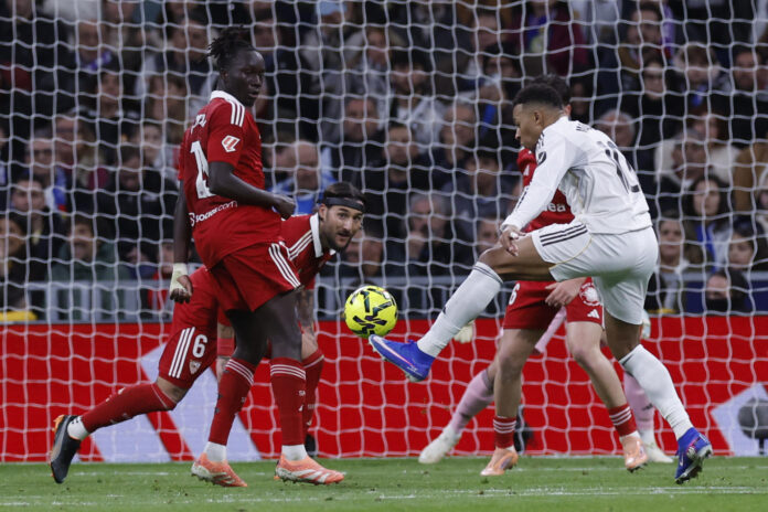 El delantero francés del Real Madrid, Kylian Mbappé (d), intenta controlar el balón ante los defensores del Sevilla durante el encuentro de la jornada 17 de LaLiga en Madrid en foto de archivo de Javier Lizón. EFE
