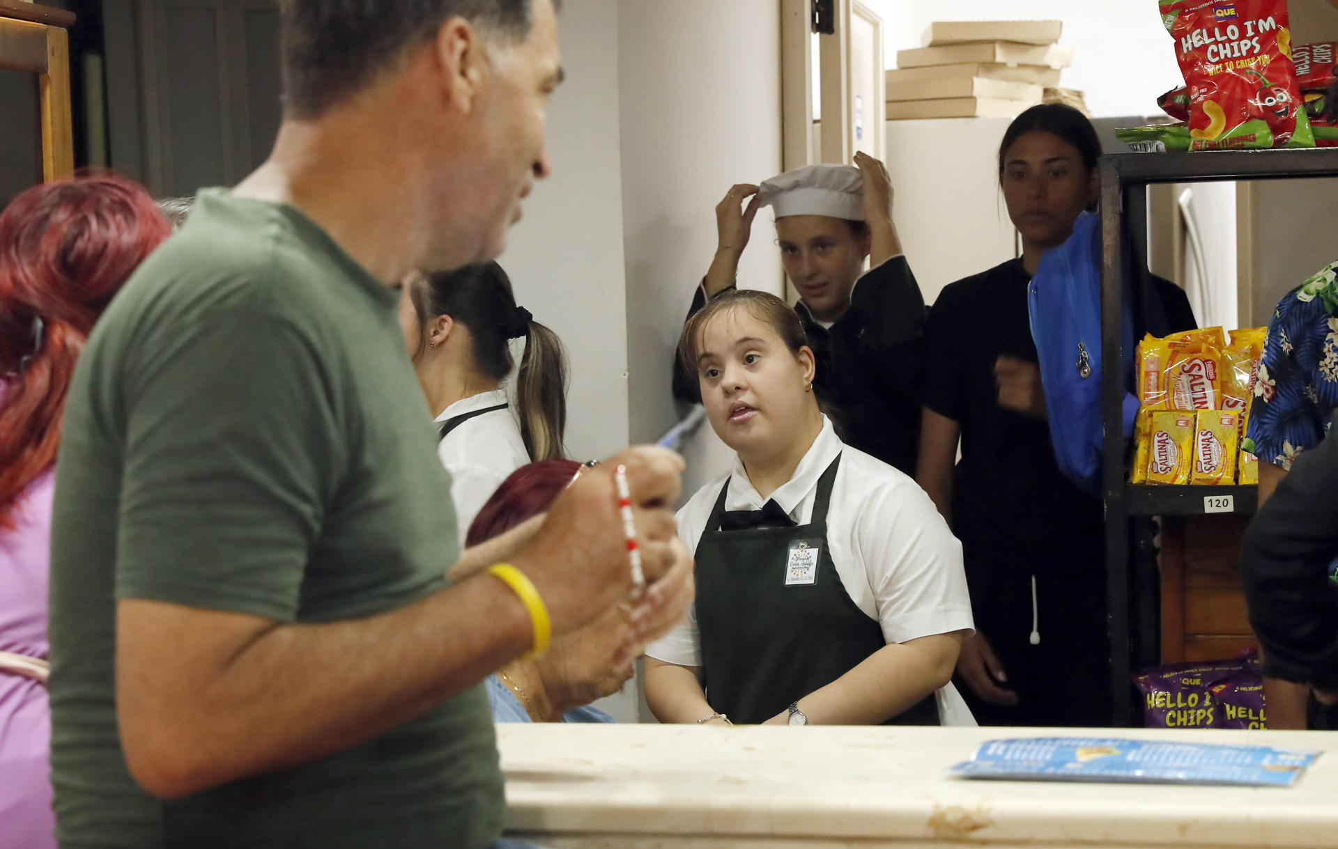 Una joven con síndrome de Down observa a clientes en la cafetería donde trabaja en La Habana (Cuba). EFE/ Ernesto Mastrascusa
