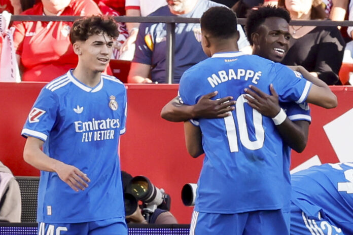 El delantero del Real Madrid Vinicius Jr. (d) celebra su gol durante el partido de la jornada 37 de LaLiga que Sevilla FC y Real Madrid disputan en el estadio Ramón Sánchez-Pizjuán, en Sevilla. EFE/José Manuel Vidal
