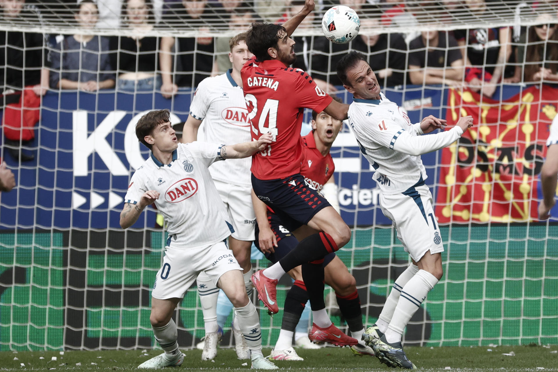 El defensa de Osasuna Alejandro Catena (c) salta por el balón con Kike García (d), del Espanyol, durante el encuentro de la jornada 37 de LaLiga entre CA Osasuna y RCD Espanyol, este domingo en el estadio de El Sadar de Pamplona. EFE/ Jesús Diges