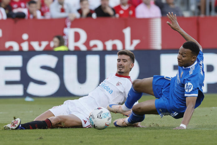 El delantero del Real Madrid Kylian Mbappé (d) disputa un balón con el defensa del Sevilla Kike Salas (i) durante el partido de la jornada 37 de LaLiga que Sevilla FC y Real Madrid disputaron en el estadio Ramón Sánchez-Pizjuán, en Sevilla. EFE/José Manuel Vidal
