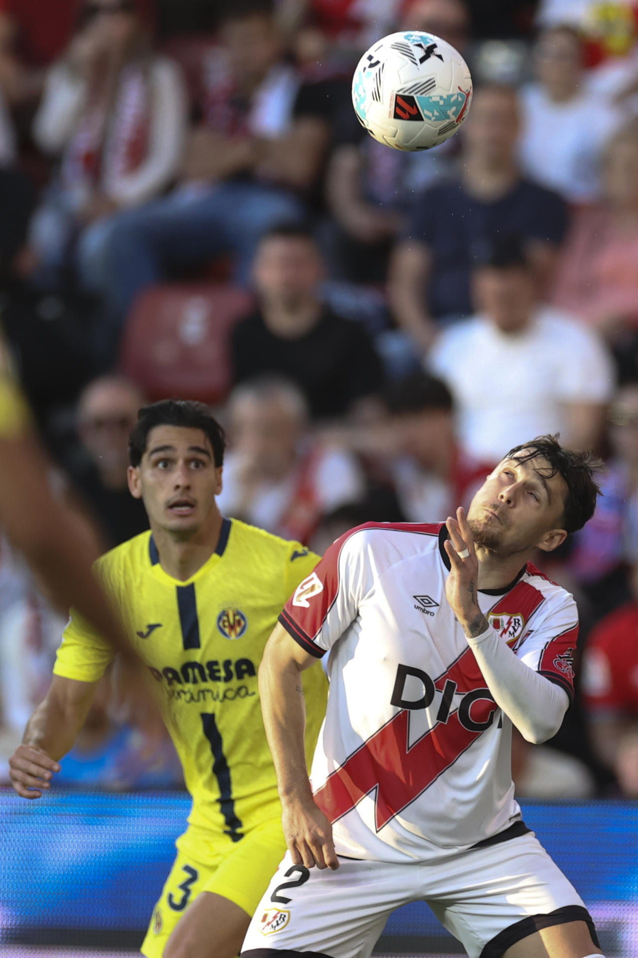 El defensa del Villarreal Sergi Cardona (i) disputa un balón con el defensa del Rayo Andrei Rațiu (d) durante el encuentro de la jornada 37 de LaLiga entre Rayo Vallecano y Villarreal CF, este domingo en el estadio de Vallecas, en Madrid. EFE/ Víctor Lerena
