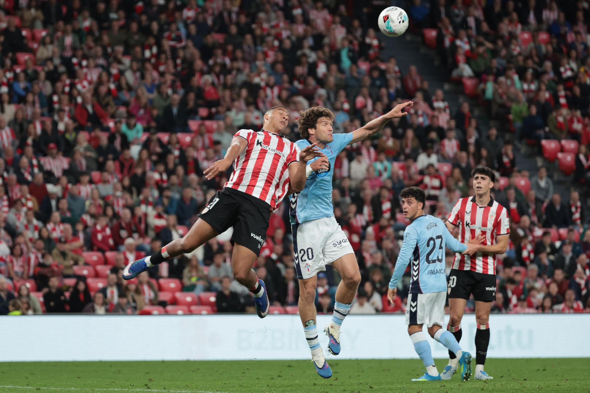 El defensa del Celta de Vigo Marcos Alonso (2i) salta por el balón con Maroan Sannadi (i), del Athletic Club, durante el encuentro de la jornada 37 de LaLiga que Athletic Club y Celta de Vigo disputan este domingo en el estadio de San Mamés. EFE/ Luis Tejido
