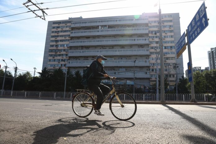 Imagen de archivo de un anciano en bicicleta frente a un edificio residencial en Pekín, China, el 20 de octubre de 2025.
EFE/EPA/WU HAO
