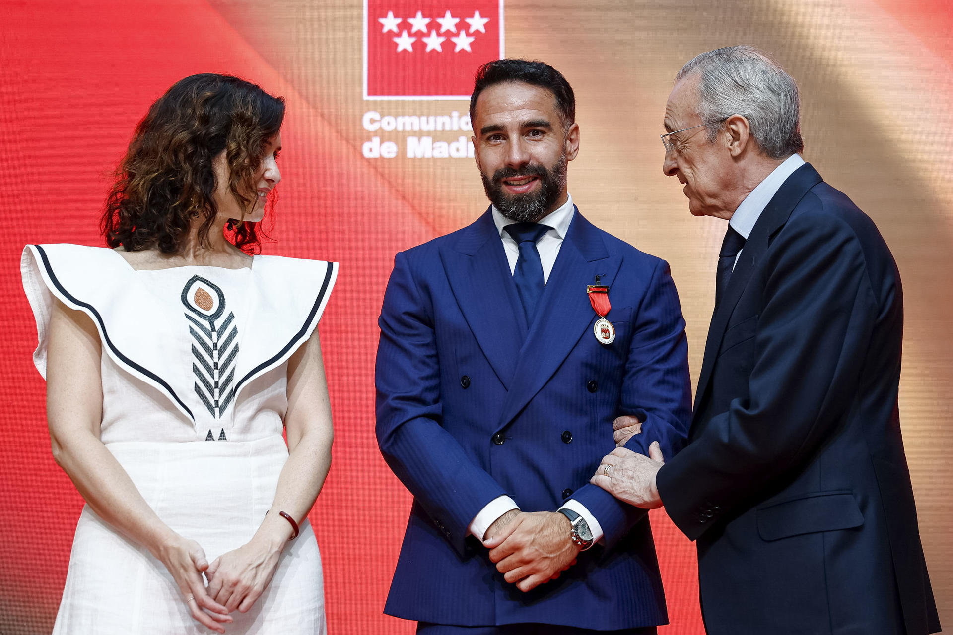 Dani Carvajal (c), junto a la presidenta de la Comunidad de Madrid, Isabel Díaz Ayuso (i) y el presidente del Real Madrid, Florentino Pérez, durante la entrega de la Medalla de Oro de la Comunidad, el pasado 27 de abril. EFE/ Daniel González
