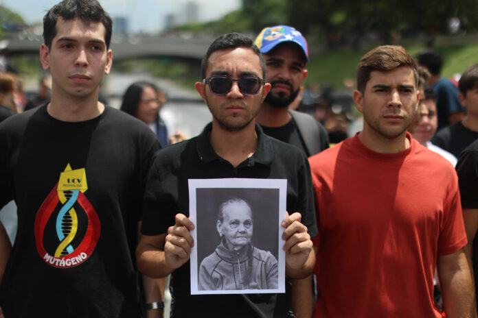 Un estudiante universitario sostiene un cartel con la imagen de Carmen Navas durante un homenaje por su muerte este lunes, en Caracas (Venezuela).EFE/ Miguel Gutiérrez

