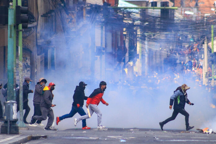 Manifestantes se enfrenta con la Policía durante una protesta, en la que exigen la renuncia del presidente Rodrigo Paz este lunes, en La Paz (Bolivia). EFE/ Gabriel Márquez
