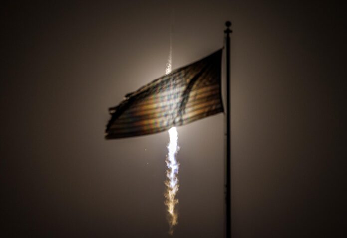 Fotografía de archivo en la que se captó el lanzamiento de una nave espacial Dragon de SpaceX, al pasar frente a una bandera estadounidense, en el Complejo de Lanzamiento 39A en el Centro Espacial Kennedy, en Florida (EE.UU.). EFE/Cristóbal Herrera
