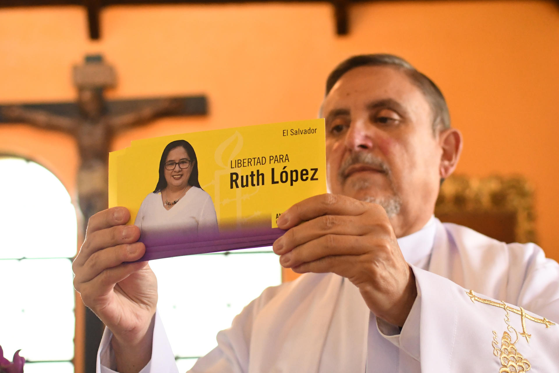 El sacerdote Miguel Cortés muestra un cartel con la imagen de la abogada salvadoreña Ruth López, durante una ceremonia religiosa este lunes, en la capilla de la Universidad Rafael Landívar, en Ciudad de Guatemala (Guatemala). EFE/ Alex Cruz
