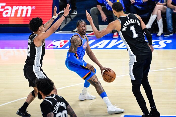 El escolta/alero de Oklahoma City Thunder Jalen Williams (C) avanza contra el escolta Dylan Harper (I) y el alero/pívot Victor Wembanyama (D), de San Antonio Spurs, durante el partido 1 de las Finales de la Conferencia Oeste de la NBA. EFE/EPA/GERALD LEONG
