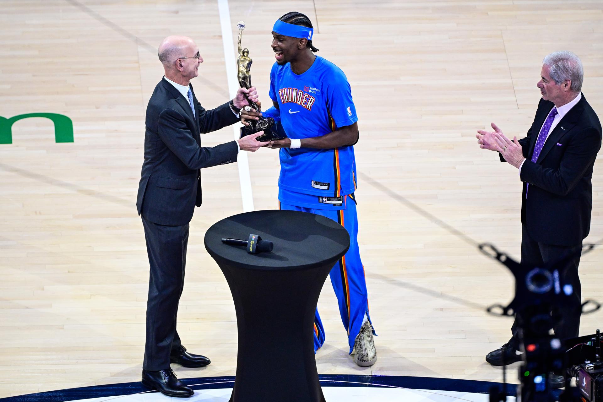 El escolta de Oklahoma City Thunder Shai Gilgeous-Alexander (C) recibe el premio MVP del Comisionado de la NBA Adam Silver (I) antes del partido 1 de las Finales de la Conferencia Oeste de la NBA ante San Antonio Spurs. EFE/EPA/GERALD LEONG
