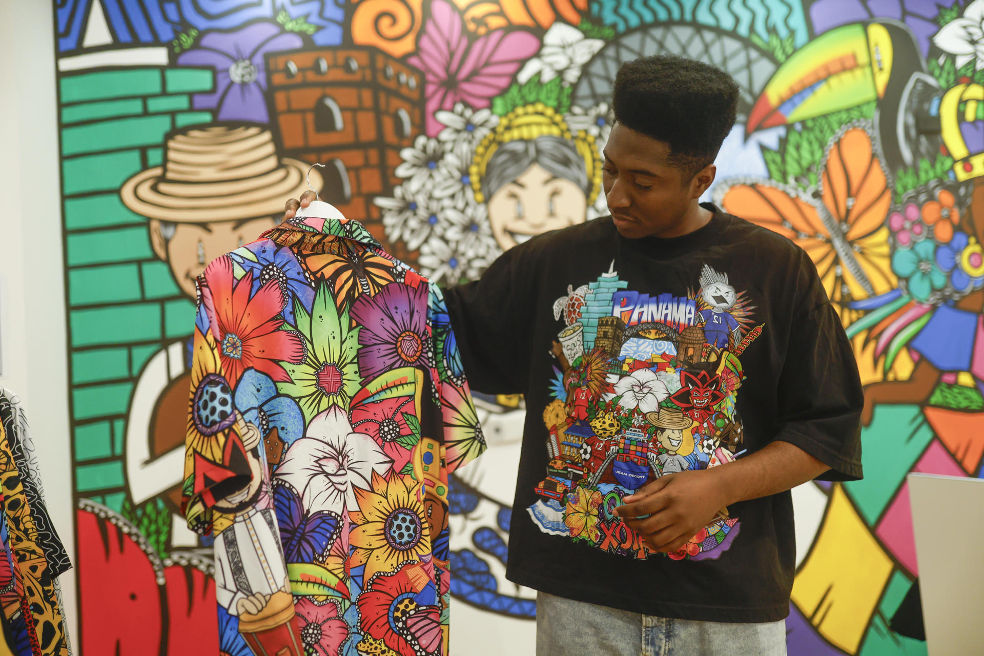 Fotografía del 12 de mayo que muestra al artista colonense Jean Quijano observando uno de sus diseños en su tienda de moda Jean Decort en ciudad de Panamá (Panamá). EFE/ Bienvenido Velasco
