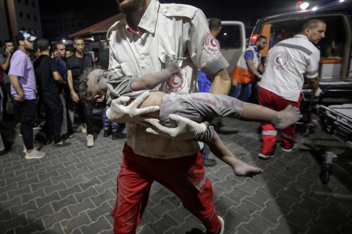En la imagen de archivo, un miembro de la Media Luna Roja ayuda a un niño palestino herido en Gaza. EFE/EPA/HAITHAM IMAD
