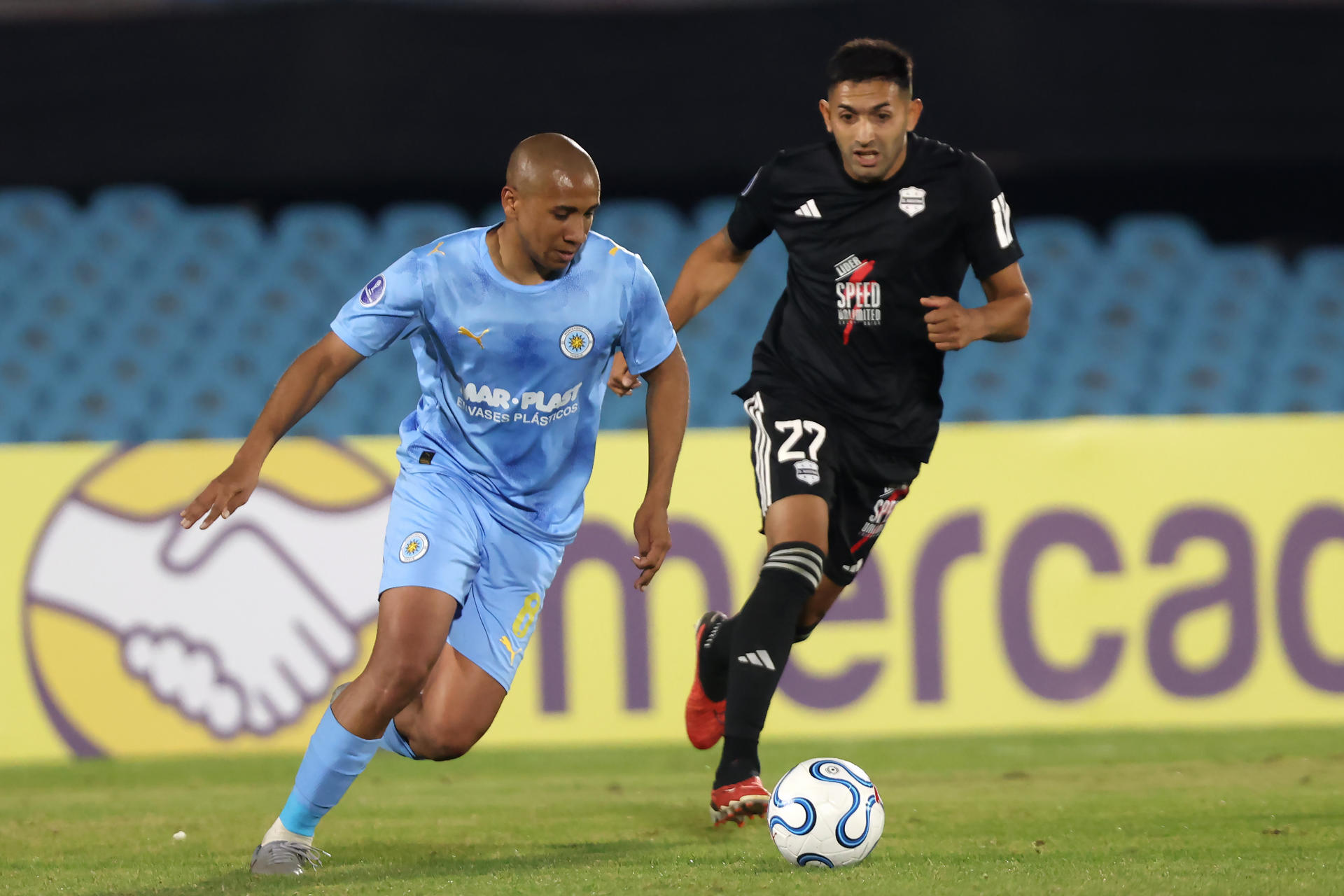 Pablo Siles (i), de Montevideo City Torque, disputa el balón con Jonatan Esteban Goitía, de Deportivo Riestra, durante un partido de la fase de grupos de la Copa Sudamericana entre Montevideo City Torque y Deportivo Riestra en el estadio Centenario en Montevideo (Uruguay). EFE/Gastón Britos
