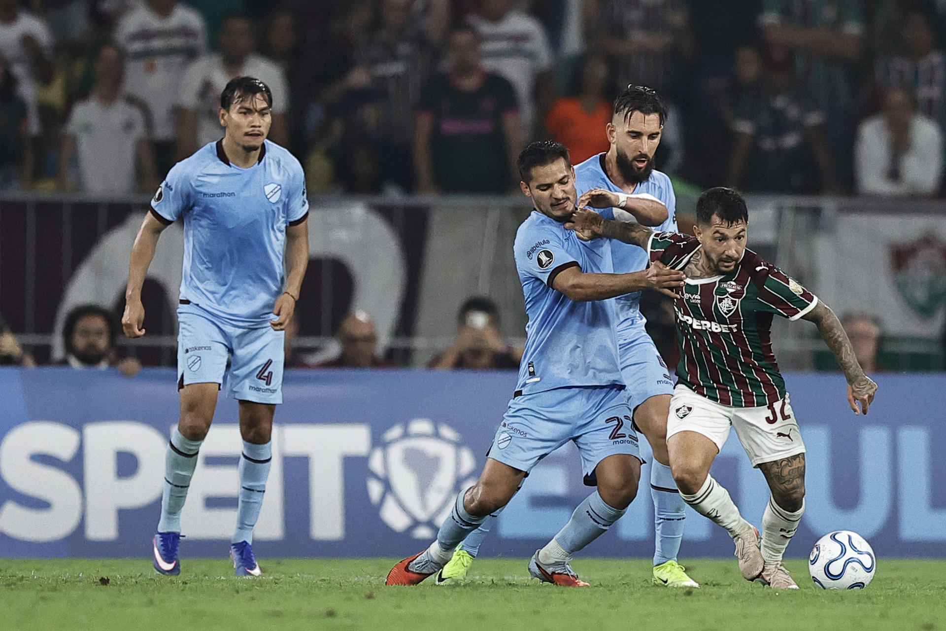 Luciano Acosta (d), de Fluminense, disputa el balón con Leonel Justiniano (c), de Bolívar, este martes durante un partido de la Copa Libertadores en el estadio Maracaná, en Río de Janeiro (Brasil). EFE/ André Coelho
