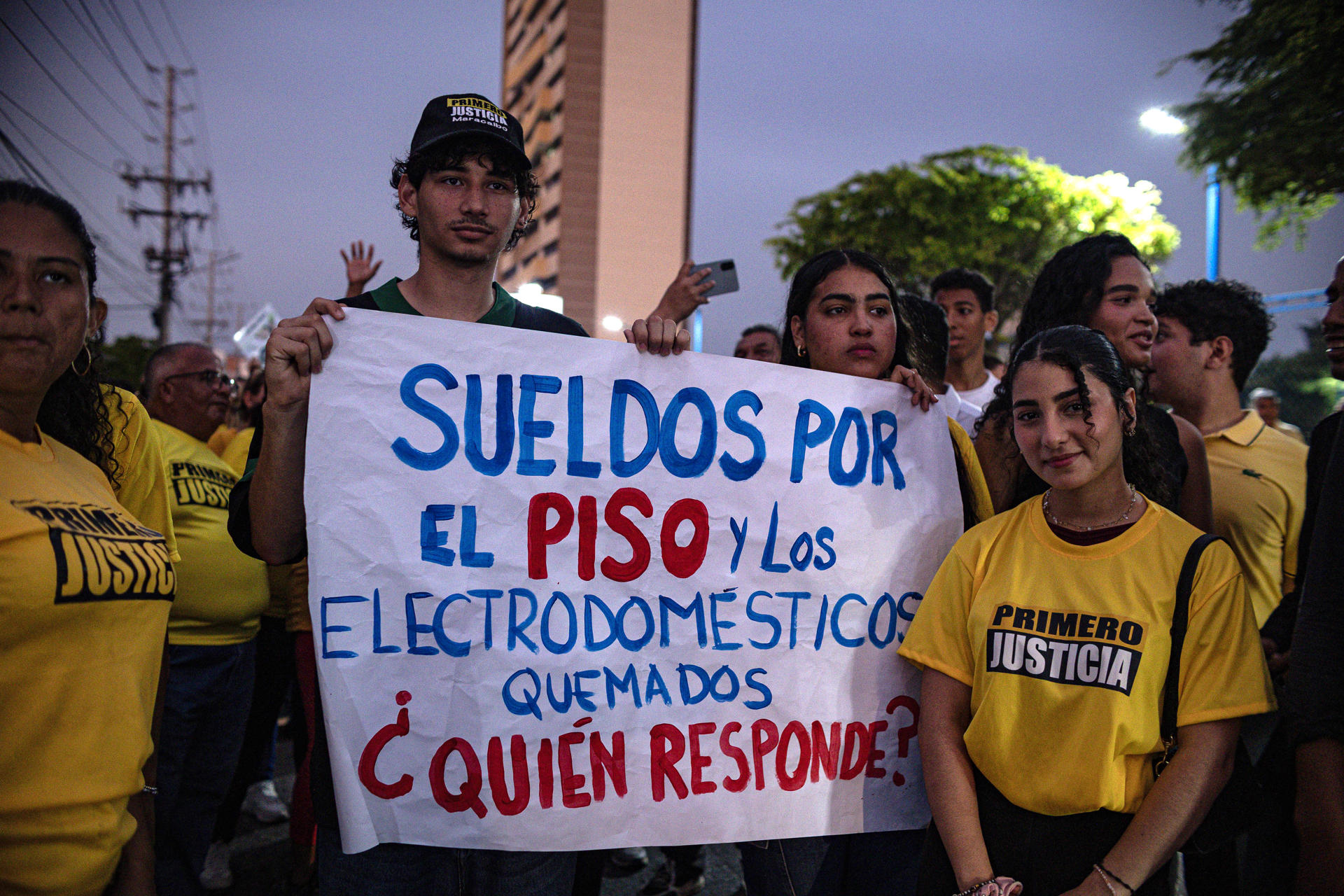 Simpatizantes del partido Primero Justicia sostienen un cartel durante una protesta por la falla en los servicios públicos este martes, en Maracaibo (Venezuela). EFE/ Henry Chirinos
