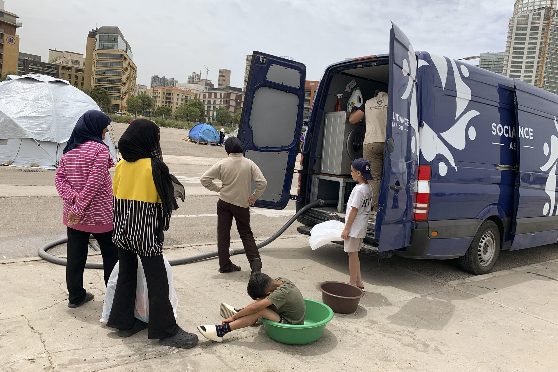 Un grupo de desplazados acude a la lavar su ropa a una tintorería ambulante gestionada por una ONG en Beirut. EFE/Noemí Jabois

