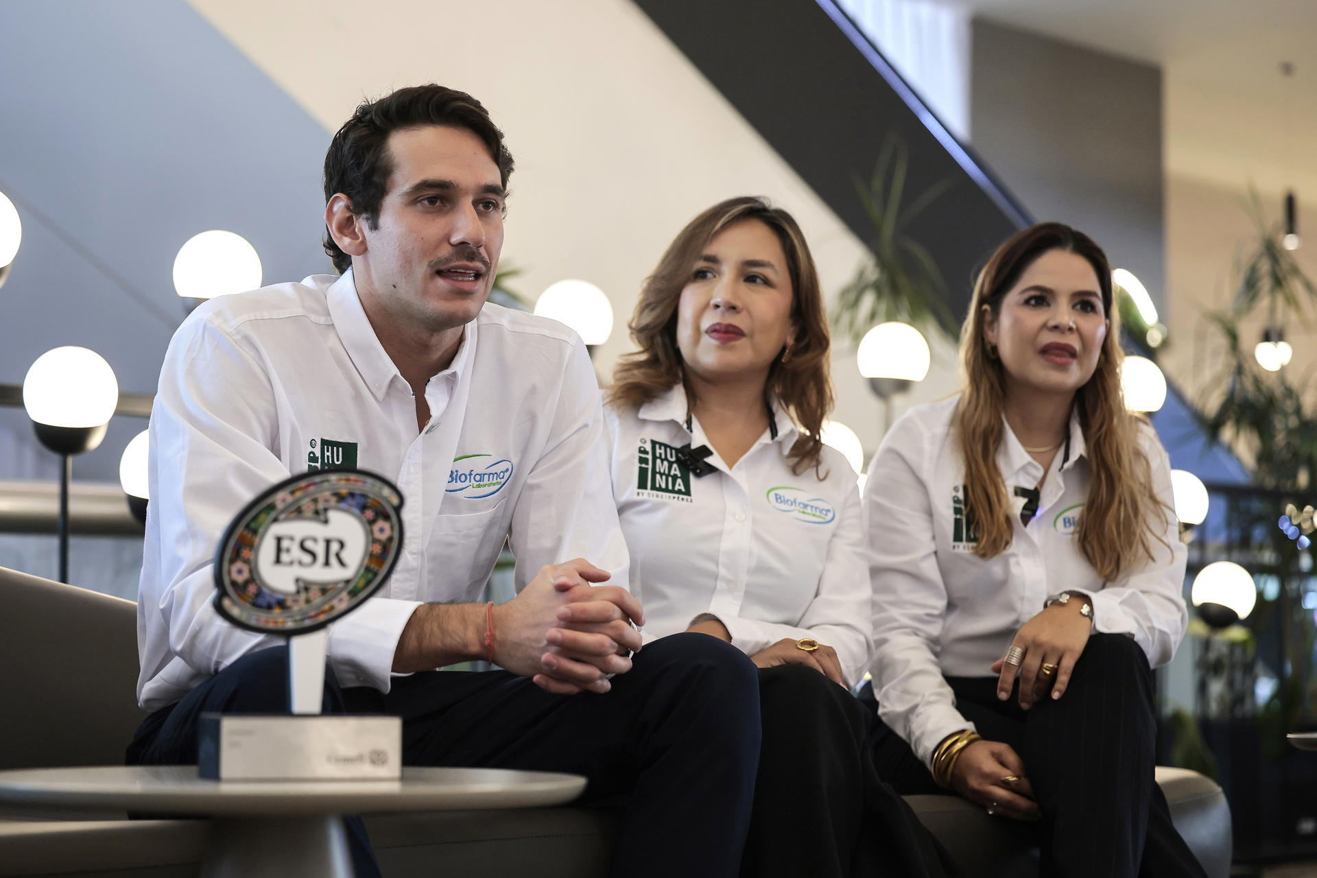 La directora general de Biofarma Natural CMD, Claudia Selene Chávez (c), el gerente de Desarrollo de Negocios de Biofarma Natural CMD, Juan Pedro Luna (i) y la gerente de Mercadotecnia y Nuevos Negocios, Natalia Gamboa (d), participan en una entrevista con EFE este martes, en Ciudad de México (México). El laboratorio mexicano Biofarma, fabricante de la línea de suplementos SP Humania, desarrollada en colaboración con el piloto mexicano de Fórmula 1 Sergio 'Checo' Pérez, recibió el distintivo de Empresa Socialmente Responsable (ESR) como parte de una estrategia enfocada en transformar su cadena de valor mediante empaques sustentables, energías renovables, apoyo a comunidades vulnerables y productos respaldados por investigación científica. EFE/José Méndez
