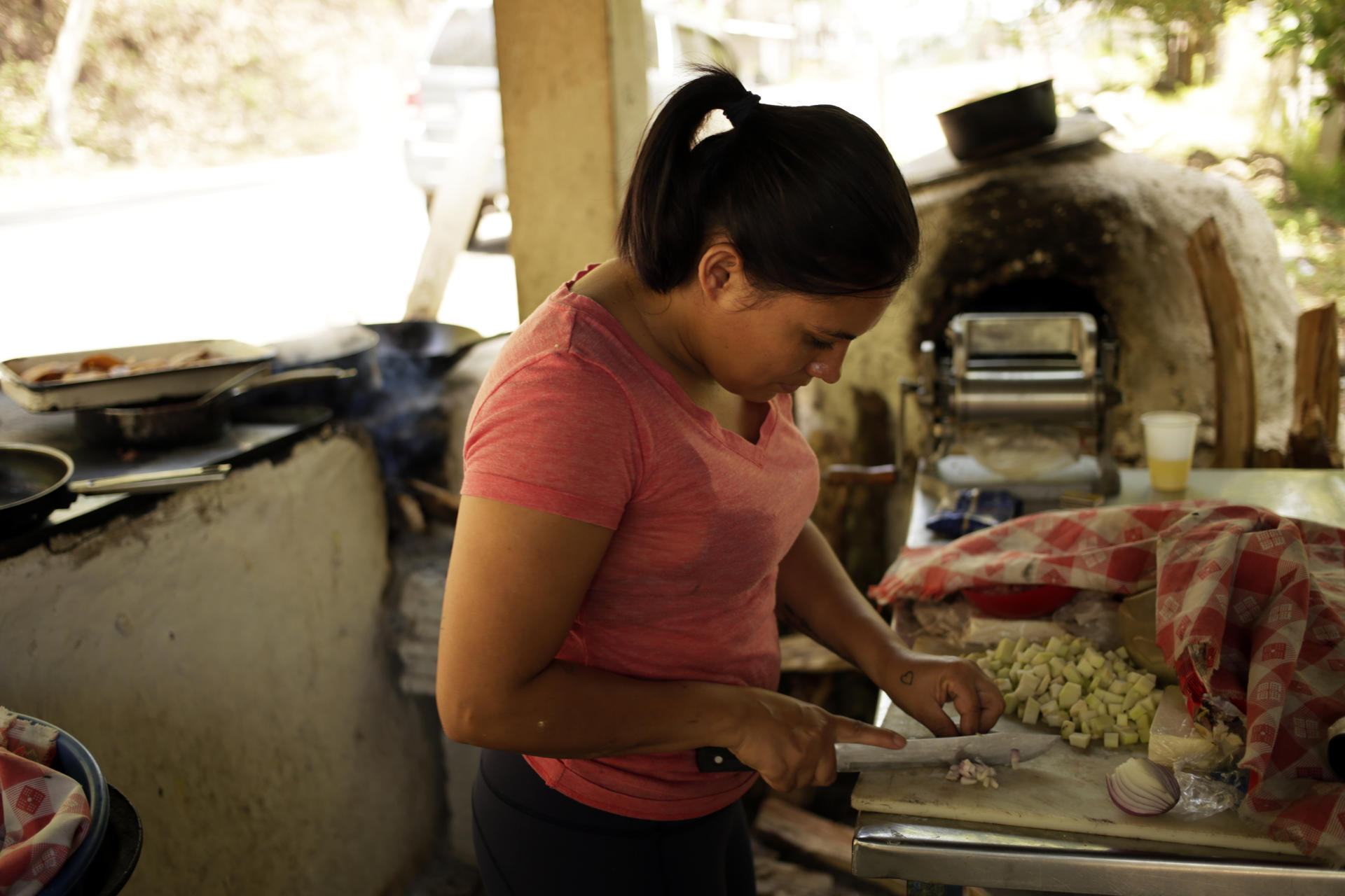 Una mujer prepara alimentos este martes, en Valle de Ángeles (Honduras). EFE/ Gustavo Amador
